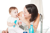 Aunt brushing her new adopted niece's teeth after making appointment atRiverwind Dental in Richmond, VA