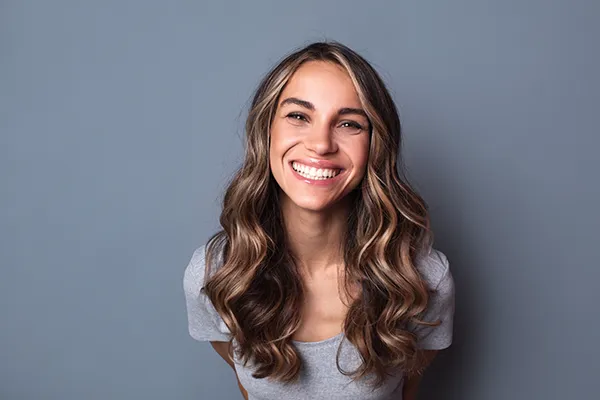 Joyful young white woman smiling and showing off her beautiful teeth and dental implants at Riverwind Dental in Richmond, VA