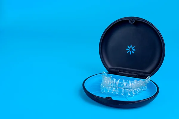 Set of clear aligners resting in an Invisalign® branded case on a blue background at Riverwind Dental in Richmond, VA Set of clear aligners resting in an Invisalign® branded case on a blue background at Riverwind Dental in Richmond, VA
