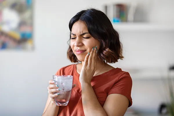 Photo of woman with jaw pain holding tea before making an appointment at Riverwind Dental in Richmond, VA