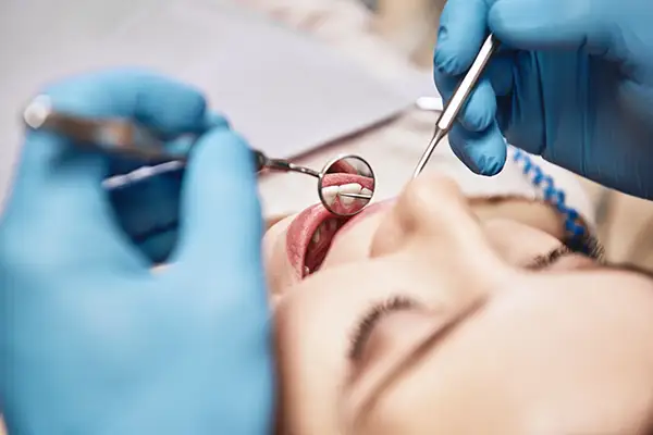 A dentist performing an oral examination on a patient at Riverwind Dental in Henrico, VA