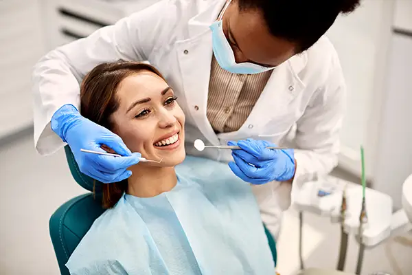A smiling female patient undergoing a dental exam performed by a dentist at Riverwind Dental in Henrico, VA