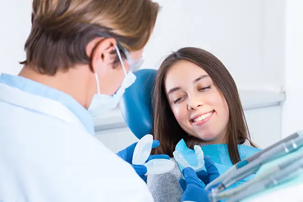 Dentist presenting mouth guard options to a smiling patient at Riverwind Dental in Henrico, VA