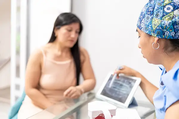 Dentist explaining oral cancer screening results on a tablet to a female patient at Riverwind Dental in Henrico, VA