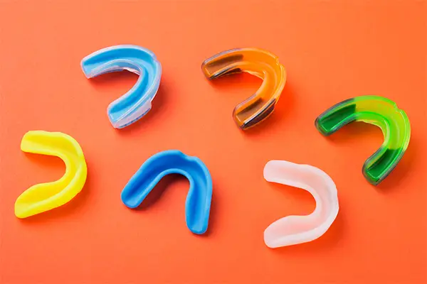 Many sports guards of different colors showcasing the variety of mouth and teeth protection options at Riverwind Dental in Henrico, VA